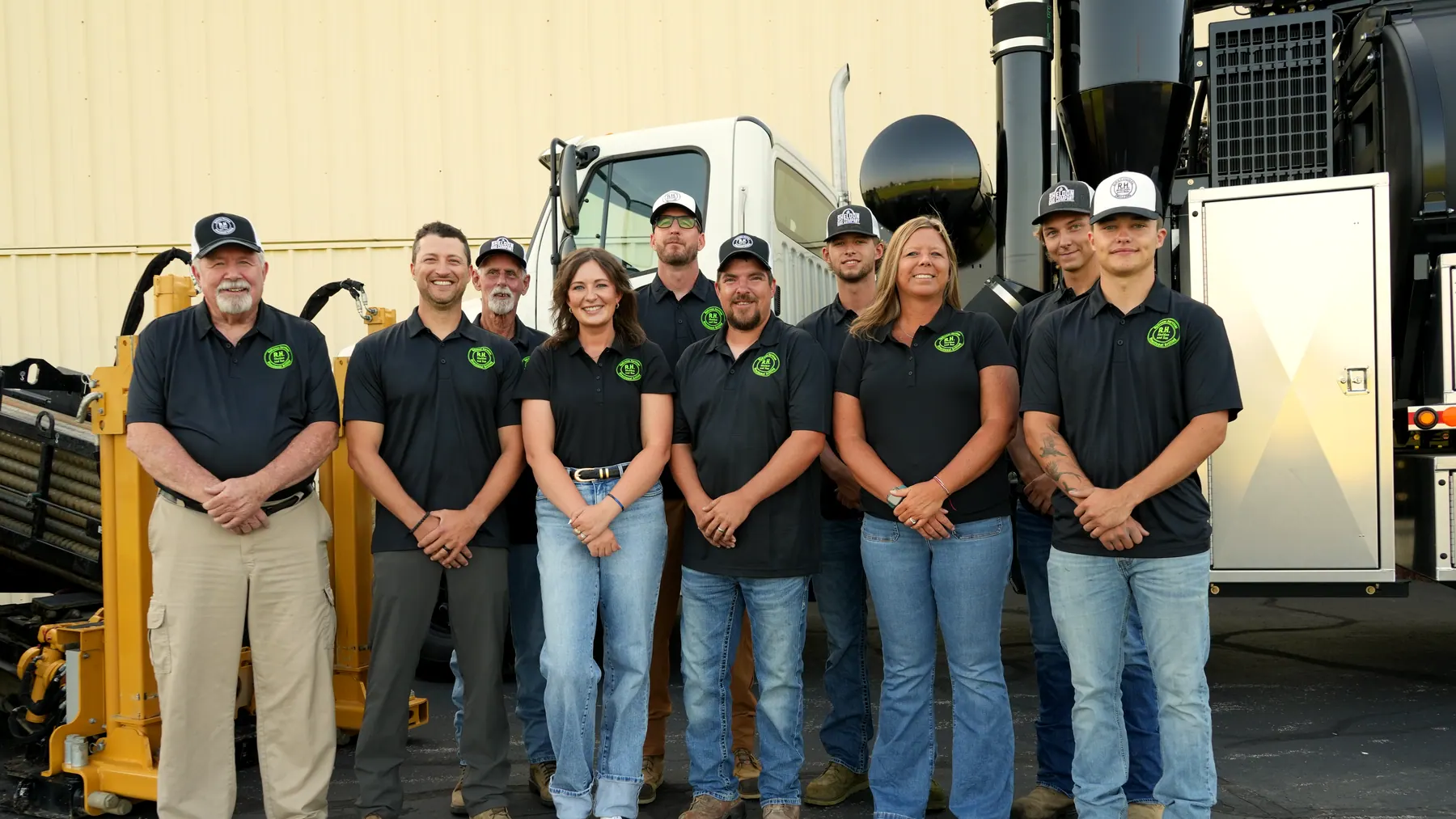 The R.H. Sheldon & Son crew standing together in front of the directional drill and the vac truck.